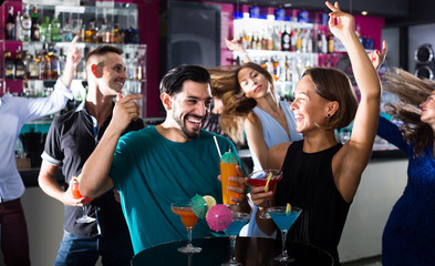 Wall Mural - adult male with female are talking and drinking cocktails on the party