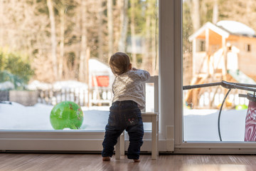 Cute little toddler balancing on a chair