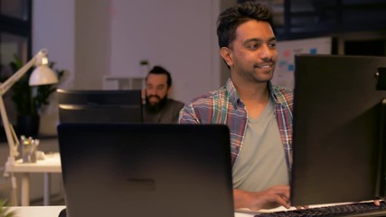 deadline, technology and people concept - creative man or programmer with laptop computer working at night office