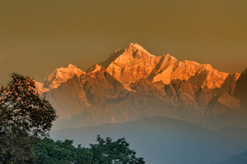 Beautiful first light from sunrise on Mount Kanchenjungha, Himalayan mountain range, Sikkim, India. Orange tint on the mountains at dawn.