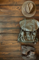 Wall Mural - jungle tropical forest, mountains hiking stuff arranged on wooden floor. backpack, hat, boots. safar