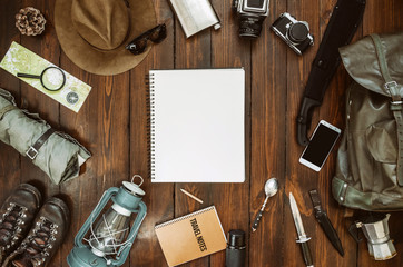 Wall Mural - mountains hiking stuff arranged on wooden floor. machete, boots, lantern, camera, hat, map, compass.