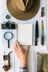 Wall Mural - adventure planning flat lay. travel vintage gear on map. traveler, explorer hand in frame holding em