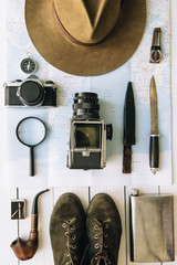 Wall Mural - adventure planning flat lay. travel vintage gear on map. including film camera, hat, knife, loupe, c