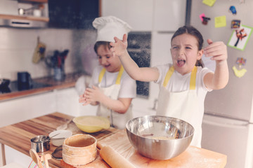 Boy and girl baking together in the home kitchen. Little bakers.