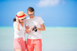 © travnikovstudio - Happy couple taking a selfie photo on white beach. Two adults enjoying their vacation on tropical exotic beach