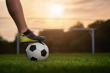 Canvas Print - Soccer ball with player in the sunset, soccer gate in the background