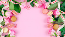 Happy Mother's Day Background Of Pink Roses And Macaron Cookies On Pink Wood Table With Copy Space.
