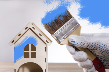 Wall Mural - Hand with brush and model house, home services. Home repairs concept.