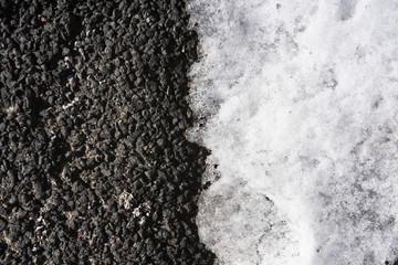 Wall Mural - Background of dark asphalt with light snow in half from above