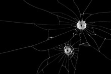 Two Bullet Holes On Window Glass Cracks Isolated On Black Background.