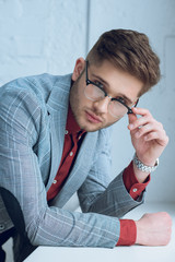Fototapete - Bearded young man wearing stylish glasses leaning on windowsill