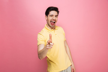 Canvas Print - Portrait of a joyful young man pointing finger at camera