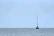 A small sailing ship with sails down, one at sea