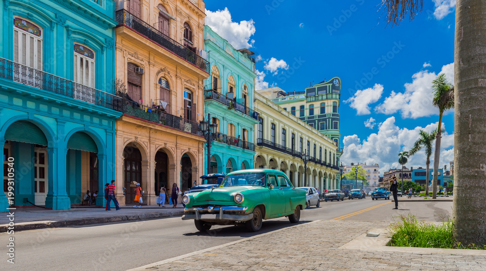 HDR - Grüner Oldtimer fährt auf der Hauptstraße in Havanna Stadt Kuba an der historischen Häuserfront vorbei - Serie Kuba Reportage - obrazy, fototapety, plakaty 