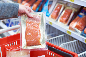 Wall Mural - Pack of salmon in hand at store