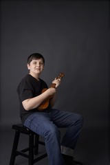 young boy or youth with Ukulele taking music lessons