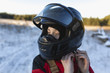 © Cavan Images - Close-up of teenage boy wearing helmet on snow covered field against sky