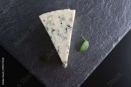 Zdjęcie XXL niebieski ser na czarnym tle kamienia