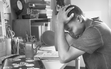 Wall Mural - Teenage boy in a bedroom doing work stressed out and frustrated