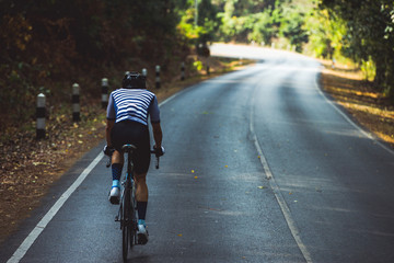 Wall Mural - Asian men are cycling road bike in the morning.He is on a forest road.