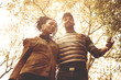 © Mladen - Young smiling African American couple walking trough park and talking.