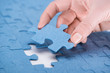 © LIGHTFIELD STUDIOS - cropped image of businesswoman inserting last missing puzzle, business concept
