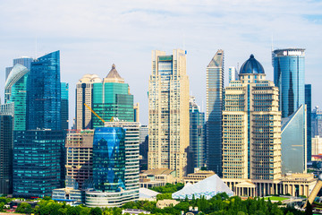 Wall Mural - Aerial view of Shanghai's high density central business area. High rise office buildings and skyscrapers with glass surface. Urban roads with multiple lanes and green city park. Shanghai, China