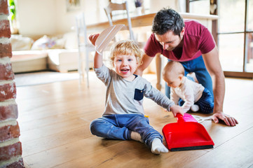 Wall Mural - Father and two toddlers with brush and dustpan.