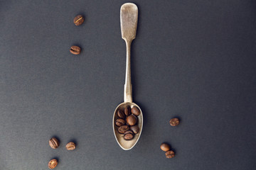 old vintage spoon and coffee beans on a dark background