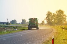 Tractor Rides On The Asphalt Road In The Sunlight