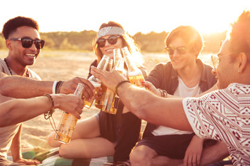 Sticker - Young group of friends outdoors on the beach drinking beer.