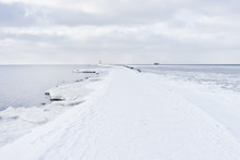 A Pier To The Lighthouse At The Mouth In Winter