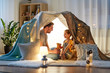 © Syda Productions - family, hygge and people concept - happy father with teddy bear toy and little daughter playing in kids tent at night at home