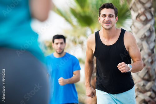 Fotografia, Obraz Portrait of adult man who is jogging with friend