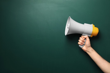 man holding megaphone near chalkboard