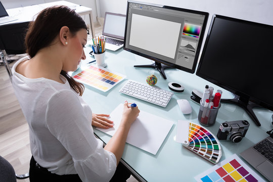 Female Designer Drawing On Blank Placard