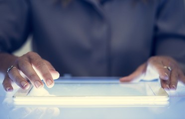 Hands holding using digital tablet on a cyber space table