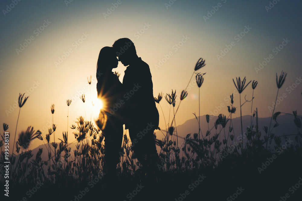 silhouette of Couple in love silhouette during sunset - obrazy, fototapety, plakaty 