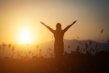 Wall Mural - Silhouette of woman praying over beautiful sky background