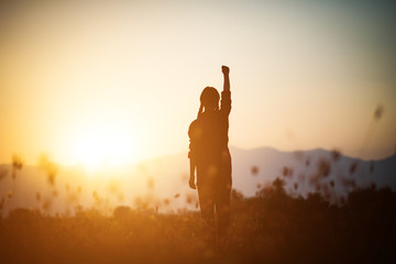 Wall Mural - Silhouette of woman praying over beautiful sky background