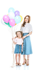 Wall Mural - beautiful mother and cute little daughter with colorful balloons smiling at camera isolated on white