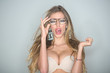 Optics shop concept. Woman with big breasts wears old fashioned eyeglasses for vision. Girl short sightedness needs modern eyeglasses. Sexy nude girl with makeup, long hair, light background.