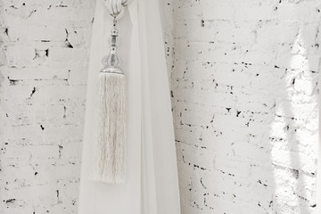 Aufkleber - Tassels of curtain on white brick background.