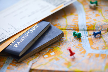 pins marking travel itinerary points on map and passport