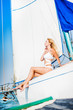 woman in fashion white swimsuit sitting on yacht