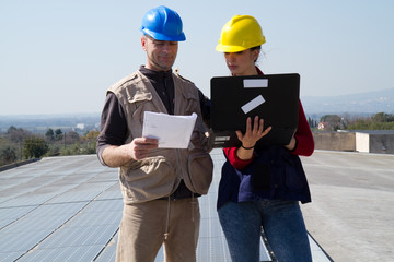 Wall Mural - young engineer girl and an elderly skilled worker fitting a photovoltaic plant