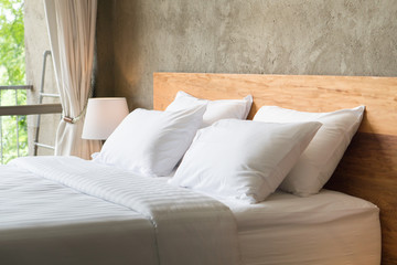 white pillows on the bed in loft style bedroom.