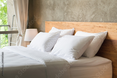 Fotografía White pillows on the bed in loft style bedroom.