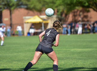 soccer player heading the ball during a match